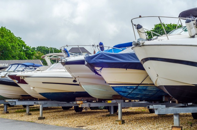 Vehicles on trailers parked in an outdoor storage lot